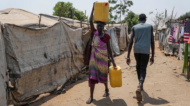 Një grua mban ujë mbi kokë, në kampin e zhvendosjeve në Juba, Sudani i Jugut, 13 shkurt 2025.